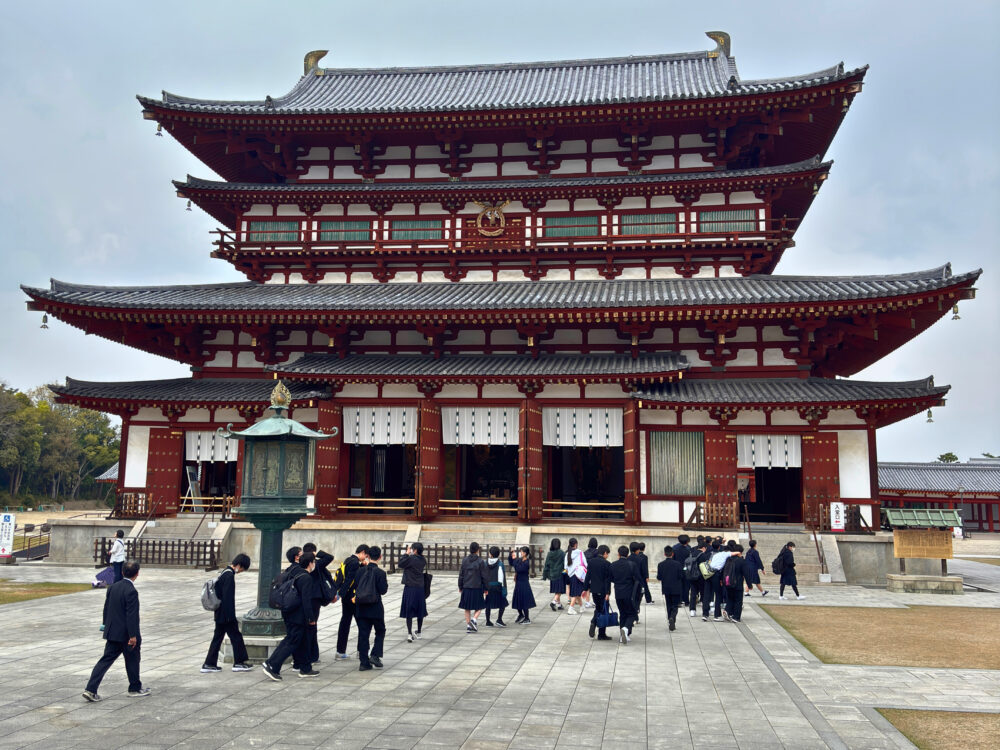 金堂前を修学旅行生が列をなして歩いている様子