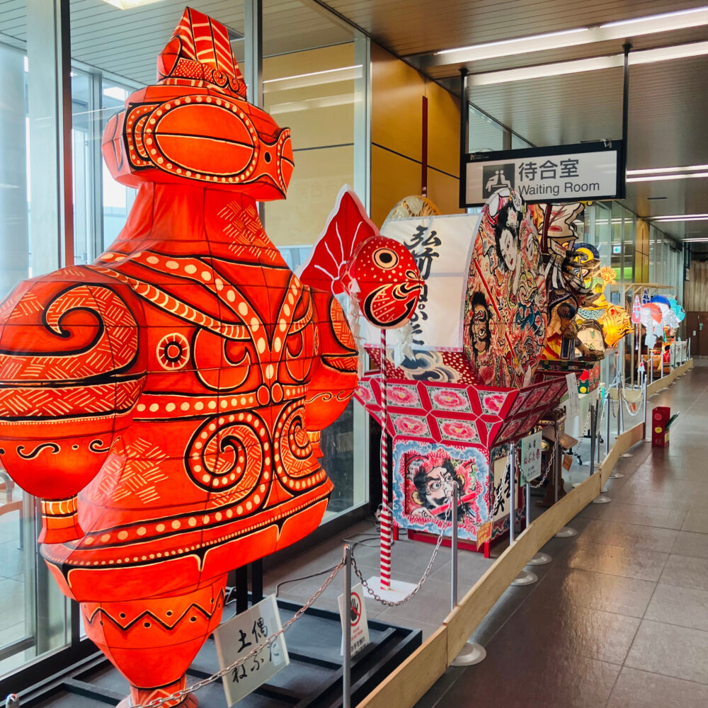 新青森駅構内に展示されているねぶたたち。土偶の形をした赤いねぶたがひときわ目をひく。