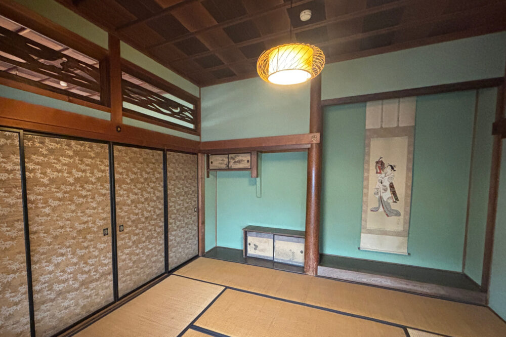 2階の客用和室。エメラルドグリーンの壁に繊細な柄の襖が女性的。