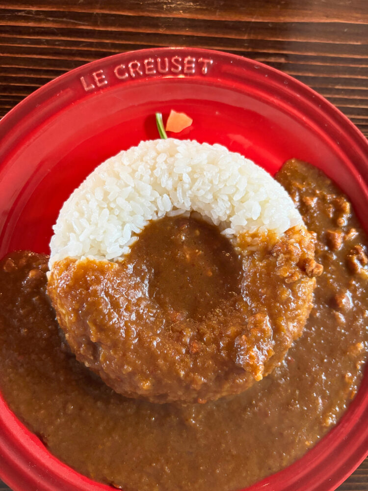 りんごをモチーフにしたりんごカレー。赤のお皿に丸く盛られたごはんがんごっぽい。