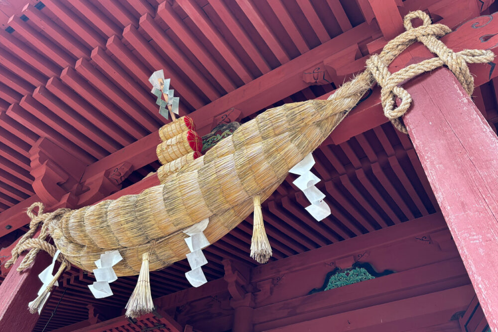 拝殿のしめ縄。米俵がのっている。