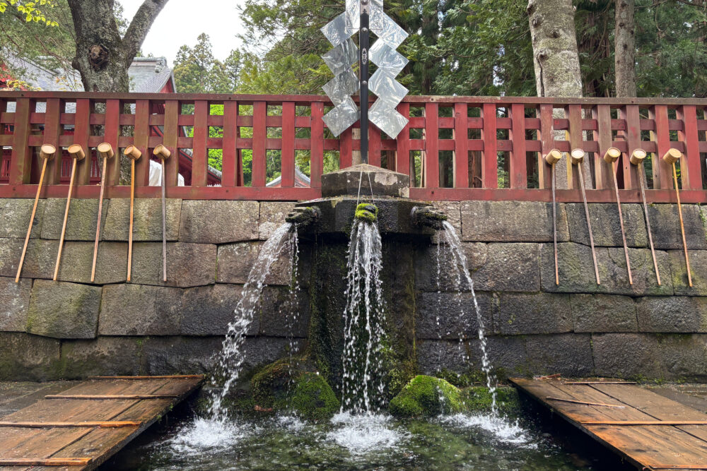 禊所の正面。三つ首の龍の口から水が出ている様子。