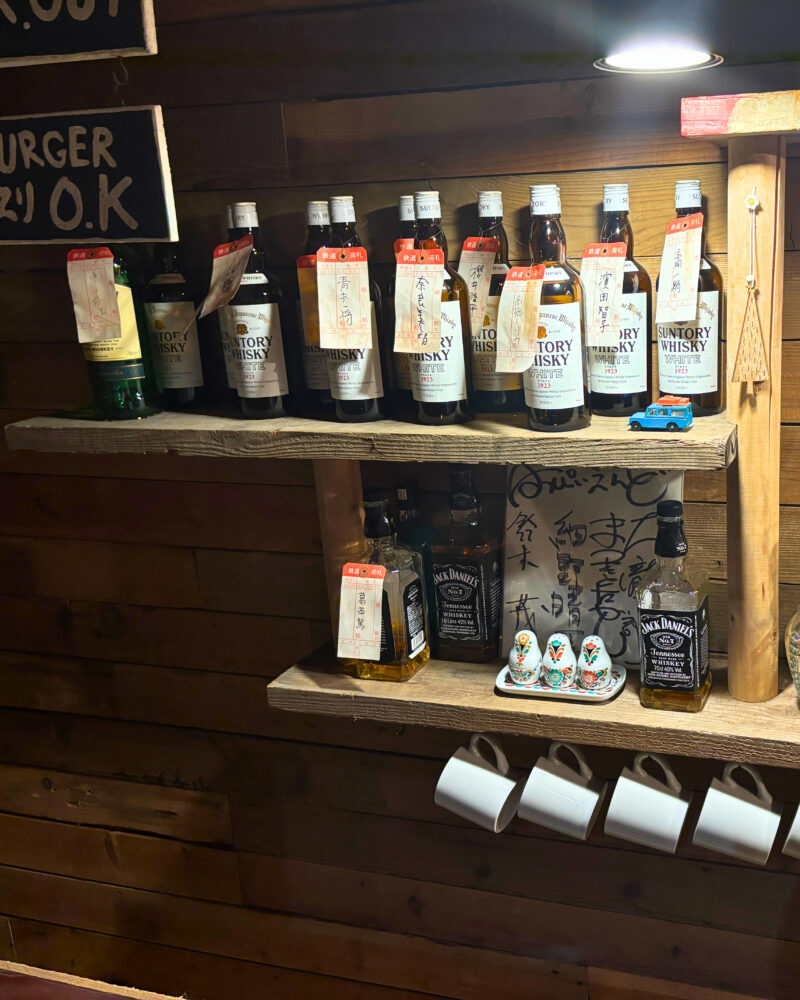 ロック喫茶「JAIL HOUSE 33 1/3」の内観。ウィスキーボトルが陳列されている。