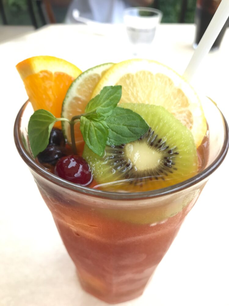 アイスティーにオレンジやキウイ、レモンが添えられたドリンク。