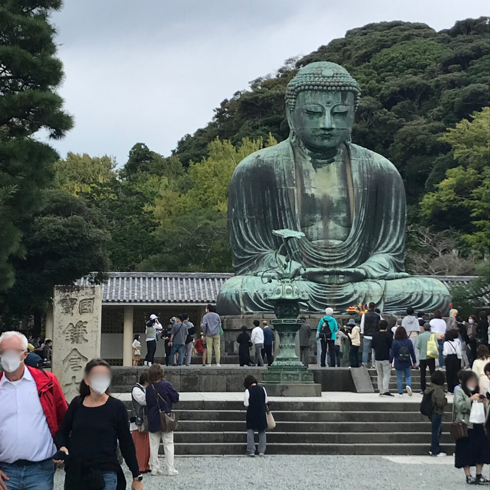 賑わう人々と鎌倉大仏を遠くから眺めた様子。