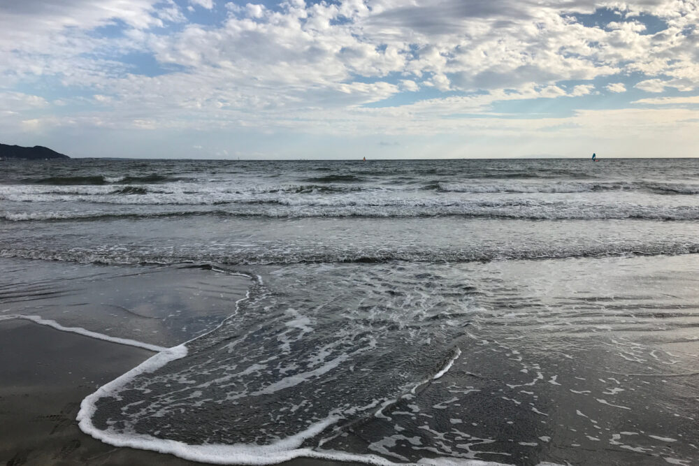 鎌倉の海岸で波が打ち寄せる夕方の風景。